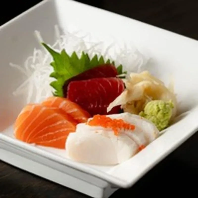 Fresh salmon, tuna, and white fish sashimi on a modern platter.