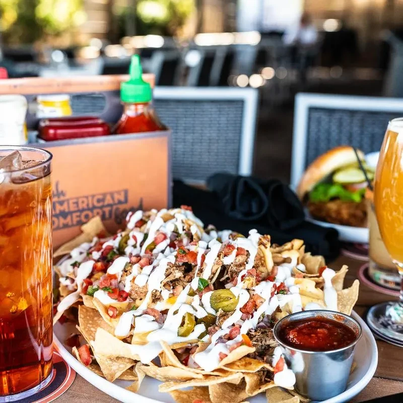 Close-up of fully loaded nachos with meat, cheese, and salsa.