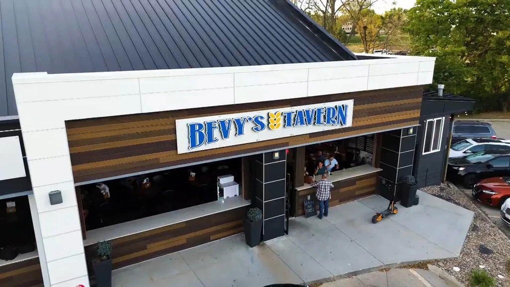 Modern Bevy's Tavern building with open windows and people inside.