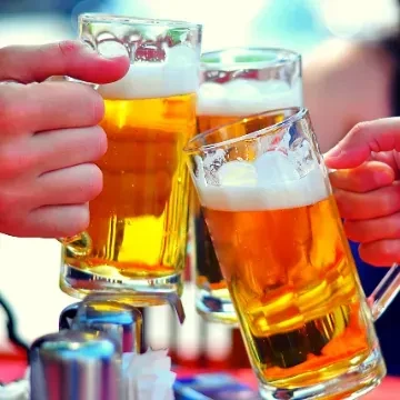 Hands clinking three mugs of golden beer in a toast.