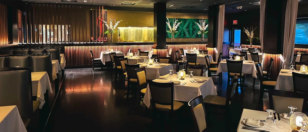 Elegant Anima's restaurant dining room with set tables and aquarium.