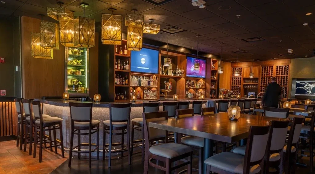 Sophisticated, warmly lit restaurant interior with a well-stocked bar.