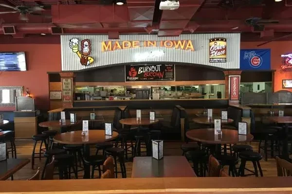 Empty rustic sports bar interior with red walls and 'MADE IN IOWA' sign.