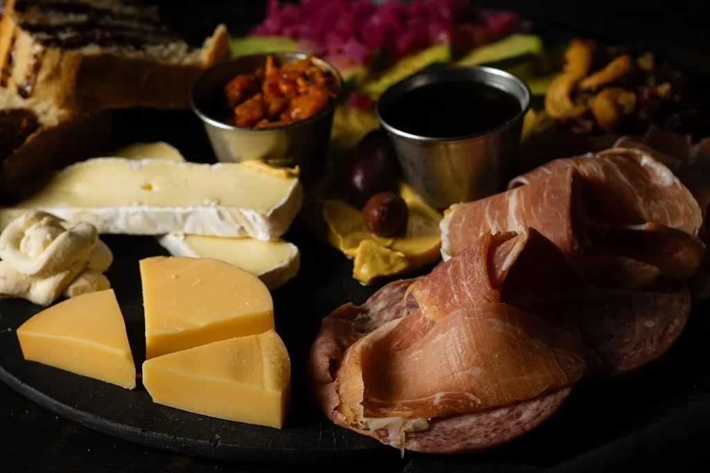 Artfully displayed cheese and charcuterie board with meats and condiments.
