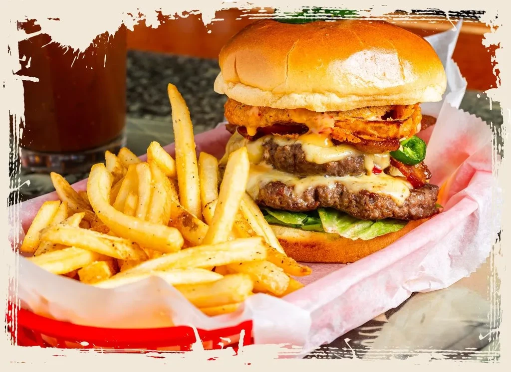 Double-patty burger with cheese, bacon, onion rings, jalapeños, and french fries.