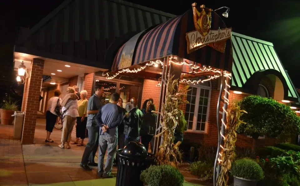 Christopher's restaurant entrance at night, lit with string lights and corn.