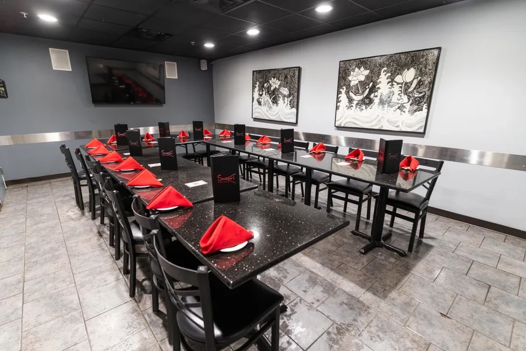 Empty, well-lit restaurant private dining area with Swagath table settings.