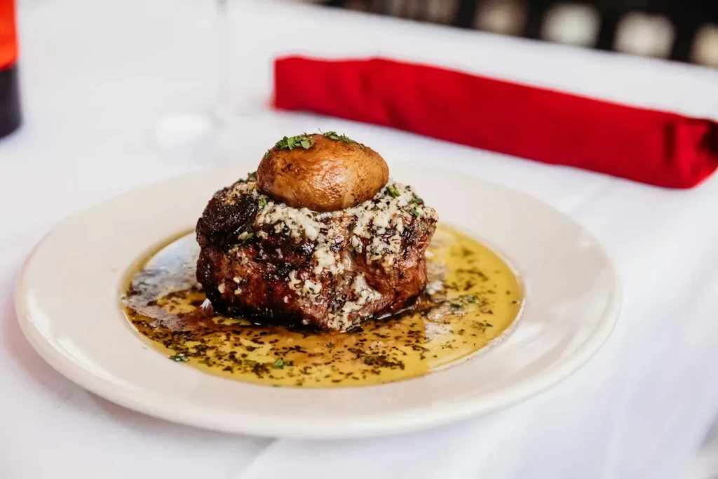 Seared steak with mushroom, crumbly topping, herbs, and golden sauce.