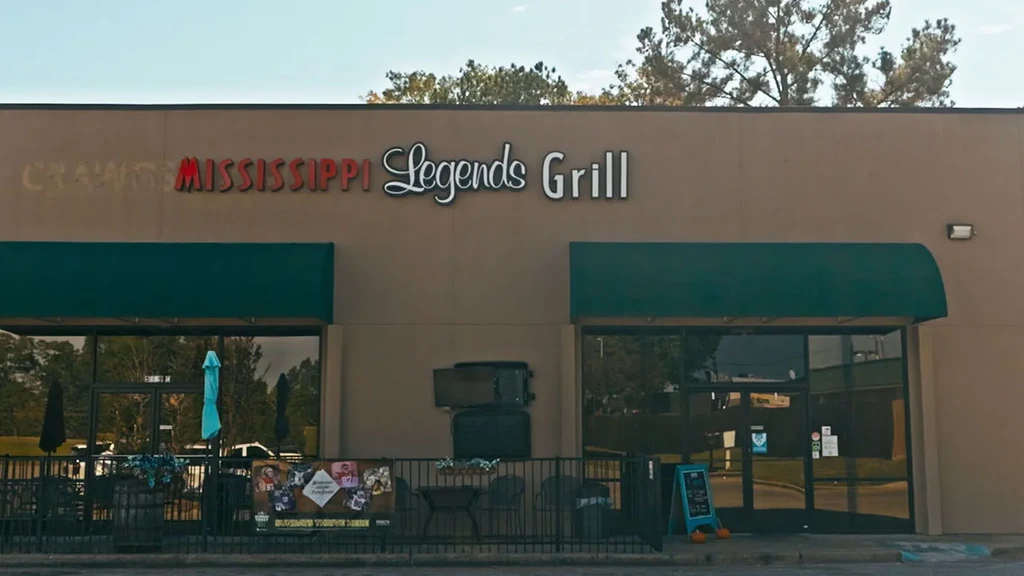 Facade of Mississippi Legends Grill with green awnings and outdoor patio.