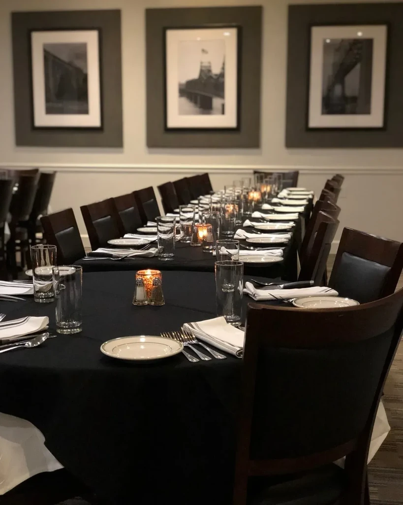 Empty restaurant dining room with a long, candlelit table.