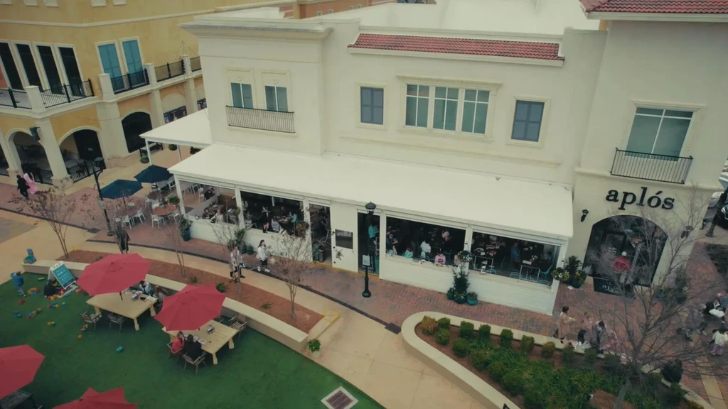 Aerial view of 'aplós' restaurant and busy outdoor plaza with diners.