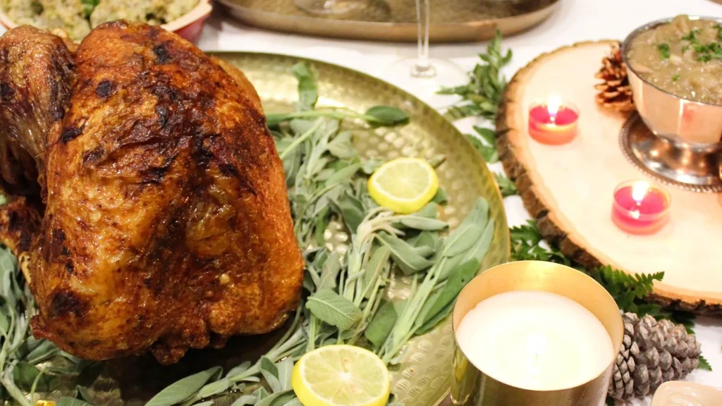 Crispy roasted turkey on a gold platter with sage and lemon.