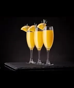 Three flute glasses with orange cocktails, garnished with orange and herb.
