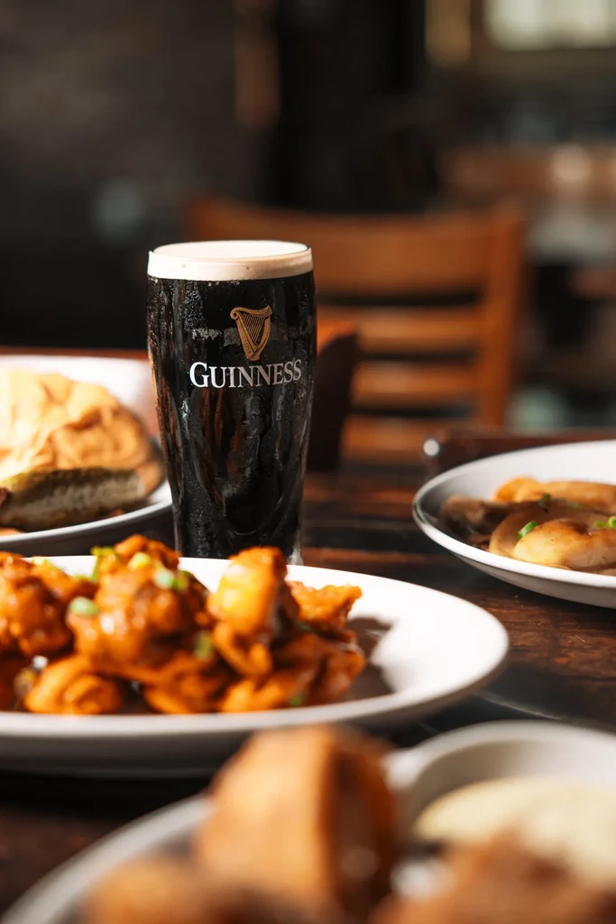 Chilled Guinness beer, crispy chicken, and appetizers in a pub.