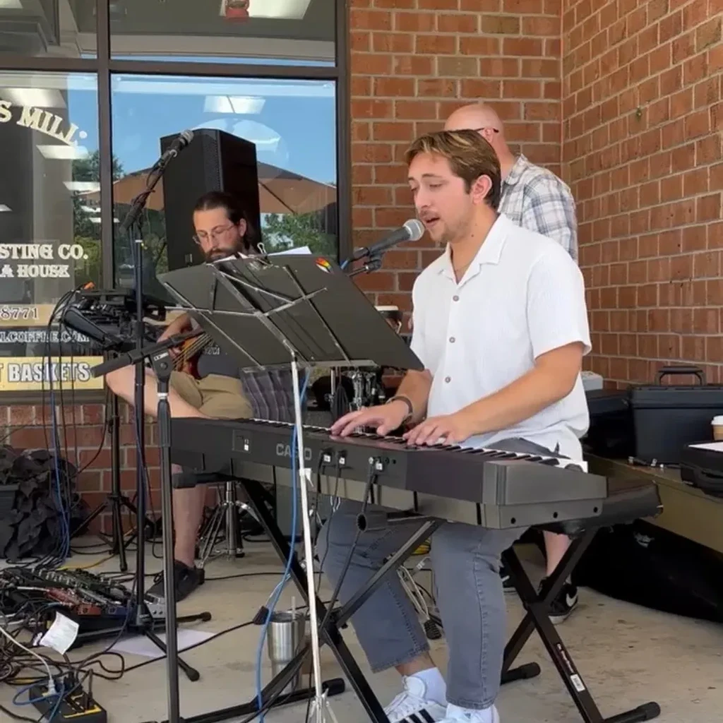 Outdoor live music performance by a band outside a coffee shop.