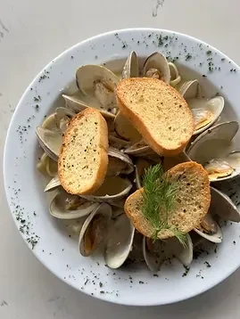 Clams in creamy sauce, topped with toasted bread and fresh dill.