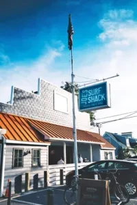 Exterior of Surf Shack building: orange roof, tall sign, sunny day.