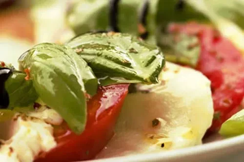 Fresh Caprese salad with basil, tomato, mozzarella, and balsamic glaze.