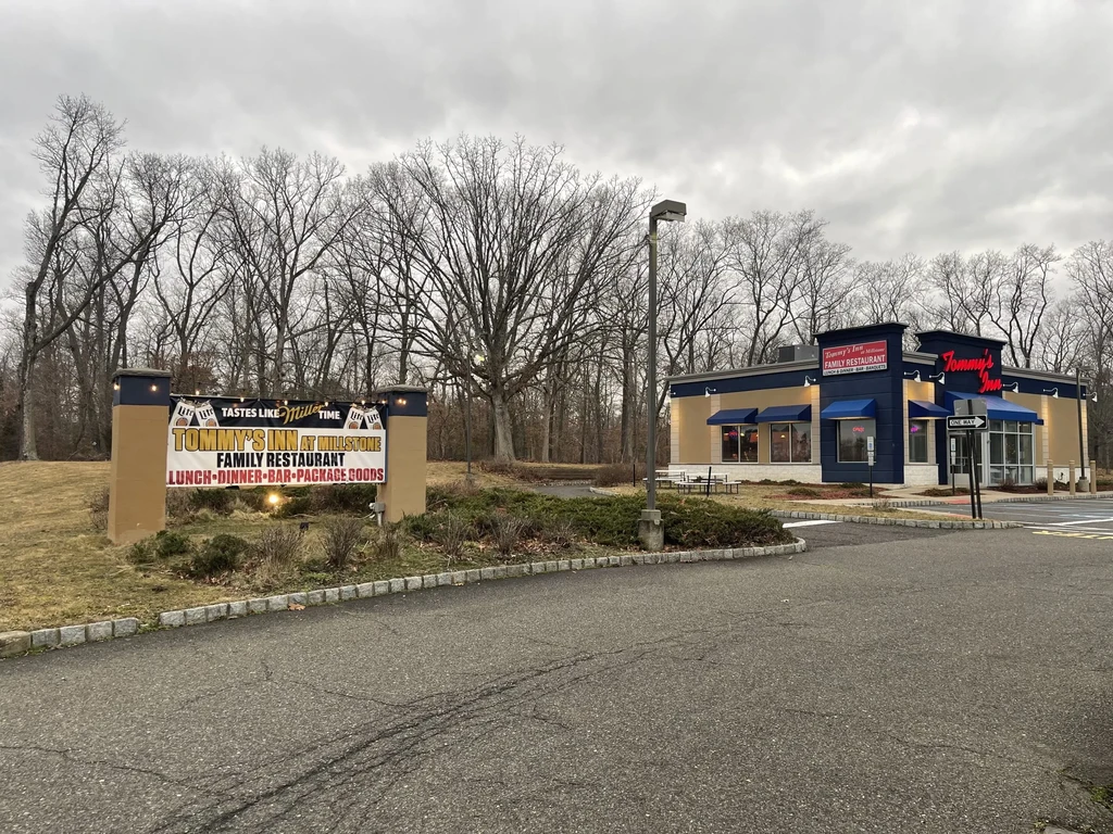 Modern Tommy's Inn at Millstone restaurant exterior and large roadside sign.