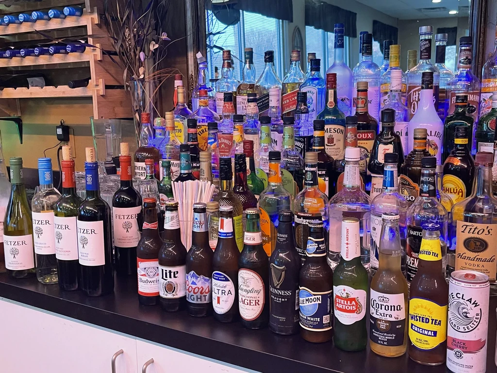 Well-stocked bar with various illuminated alcoholic beverages on a counter.