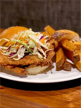 Crispy fried chicken sandwich, colorful coleslaw, and golden fries.