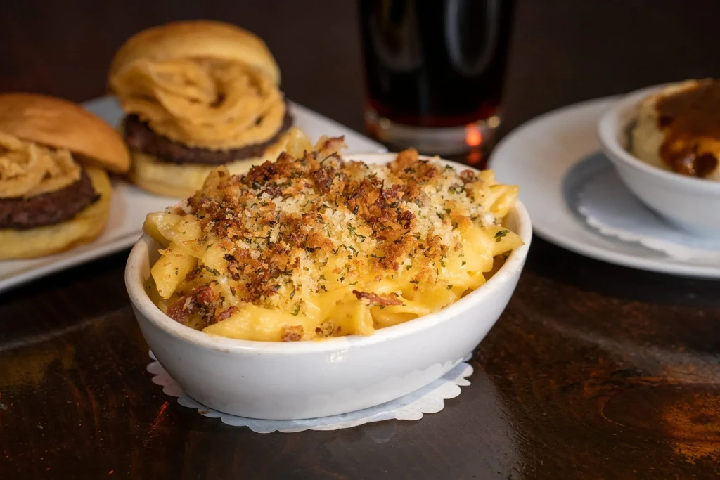 Comfort food spread: mac and cheese, sliders, mashed potatoes on table.