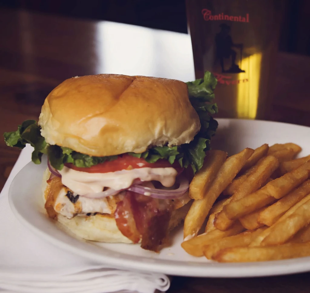 Stacked burger, fries, and beer glass at Continental Tavern.