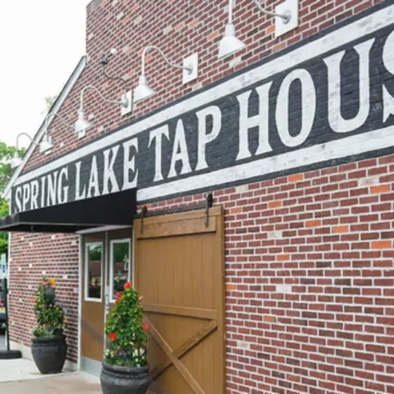 Spring Lake Tap House brick exterior, black awning, and rustic barn door.