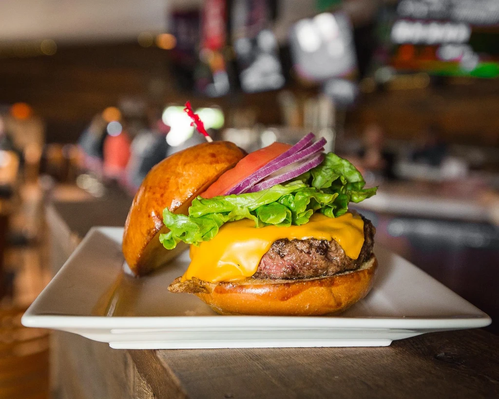 Gourmet cheeseburger with a brioche bun, melted cheese, and fresh toppings.