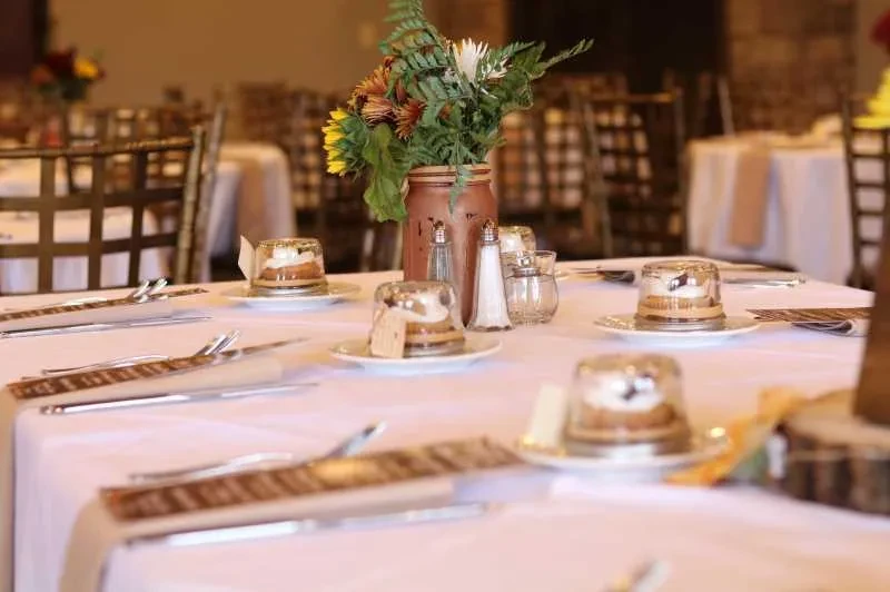 Elegant dining table with domed desserts and a sunflower centerpiece.
