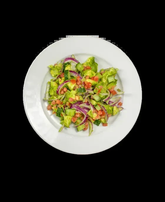Overhead photo of avocado, cucumber, red onion, tomato salad on white plate.