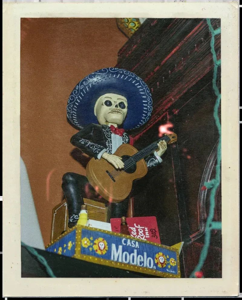 Decorative mariachi skeleton playing guitar; 'CASA Modelo' and 'Red Roof Inn' visible.