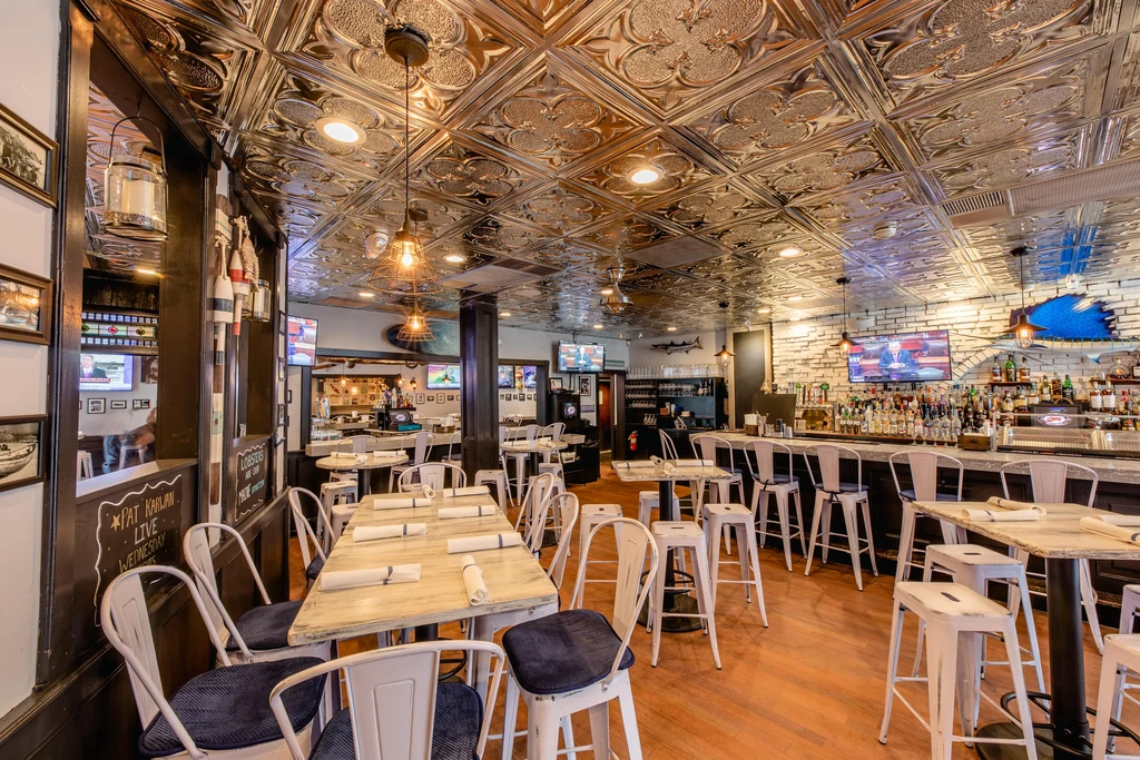 Vibrant, empty restaurant interior with ornate ceiling, bar, and tables.
