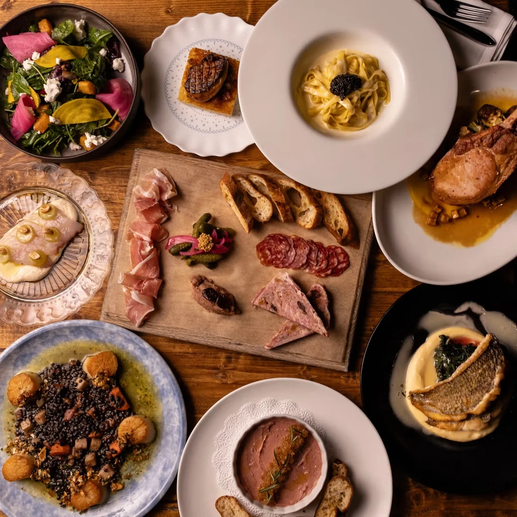 Top-down view: rustic dining table laden with diverse gourmet dishes.