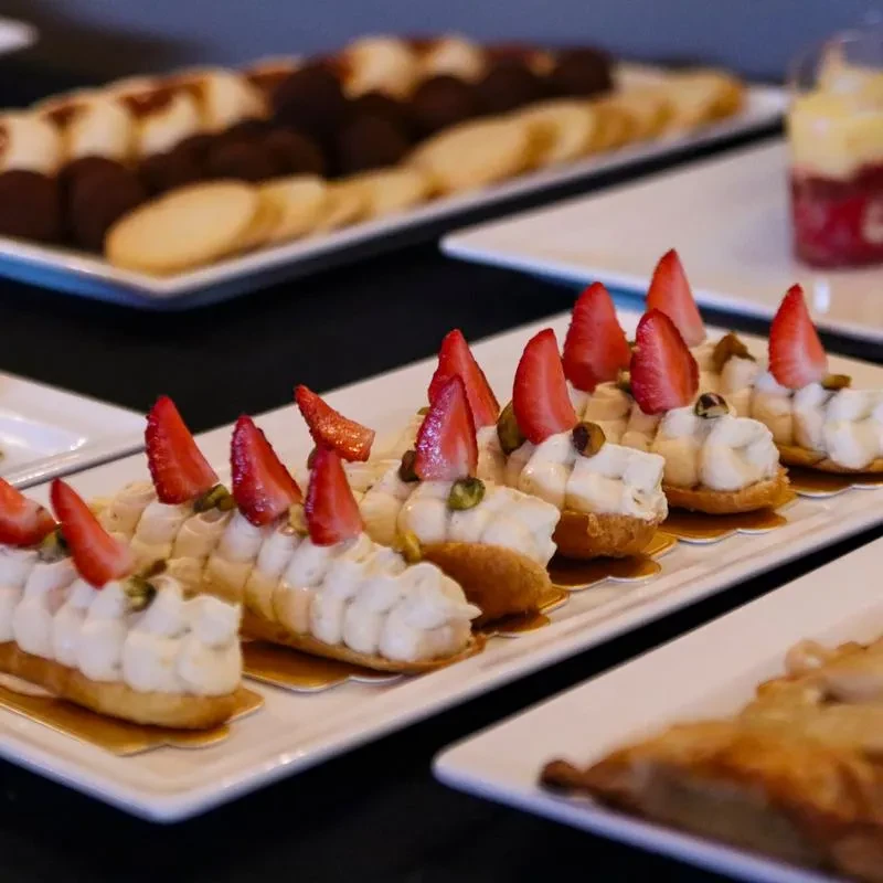 Close-up of platters with strawberry pastries, cookies, and chocolate treats.