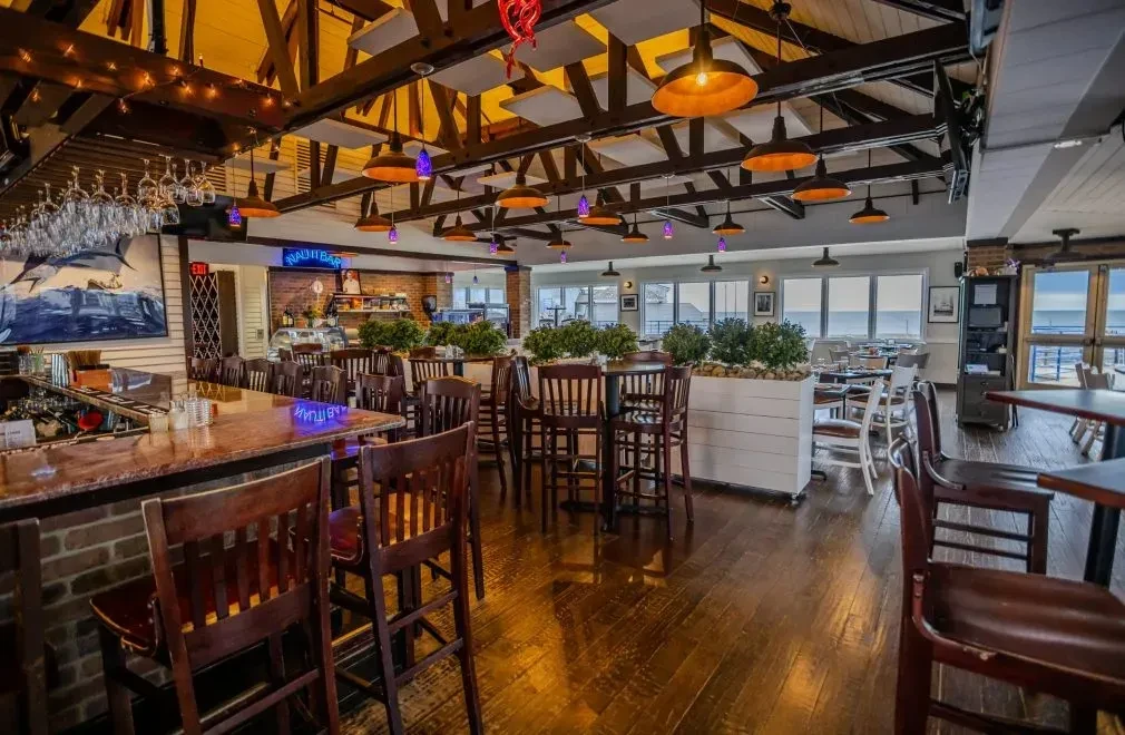 Interior of a coastal-themed bar and restaurant with ocean views.