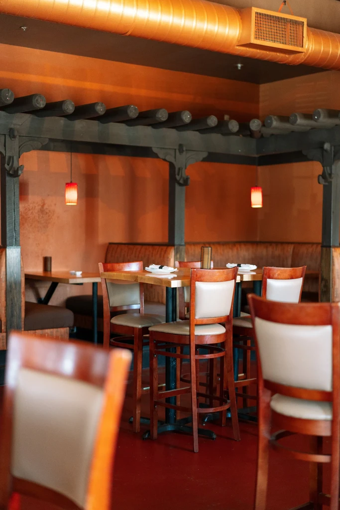 Empty, warmly lit restaurant interior with rustic and industrial decor.