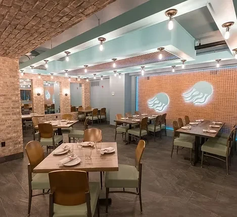 Modern, empty restaurant dining room featuring set tables and jellyfish lights.