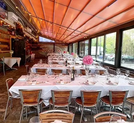 Spacious dining area with elegantly set tables, floral decor, and warm fairy lights.