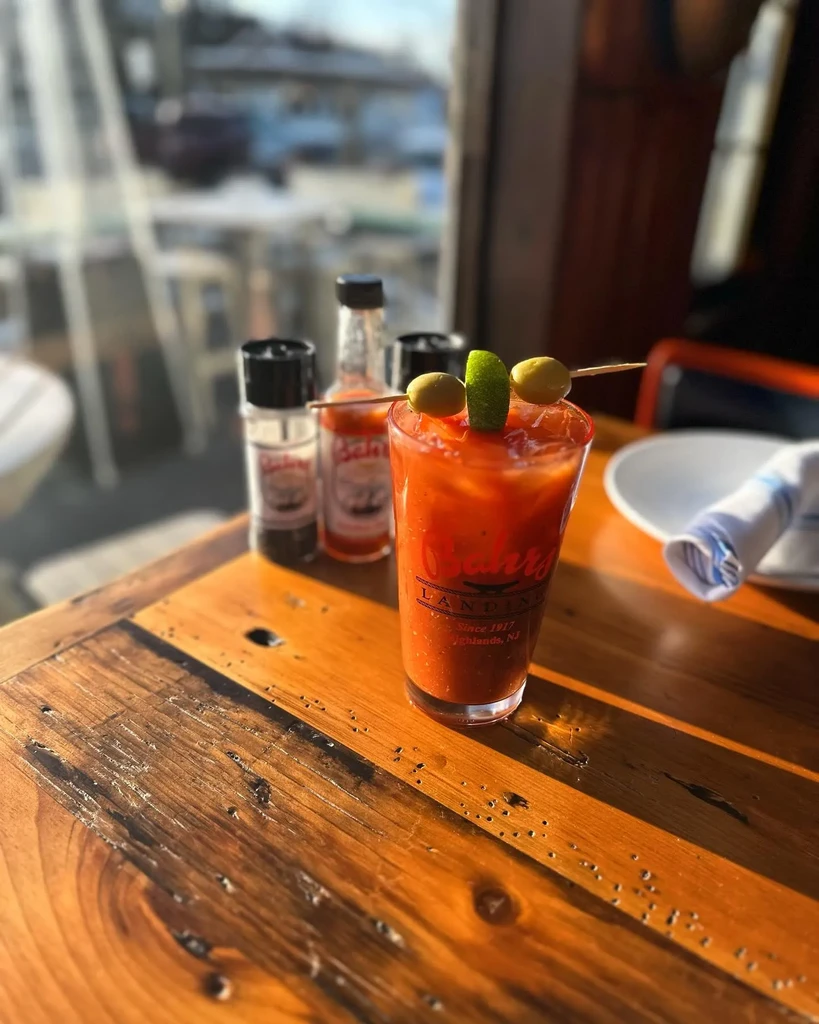 'Bahrs Landing' Bloody Mary with olive and lime garnish on a wooden table.
