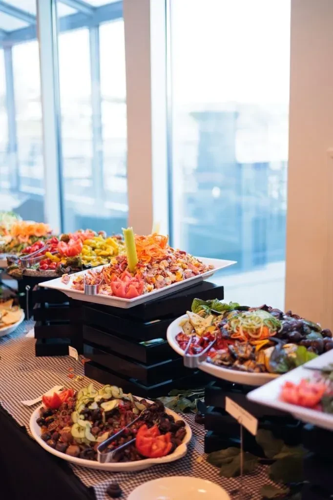 Vibrant catering buffet with colorful salads, grilled vegetables, and diverse dishes.