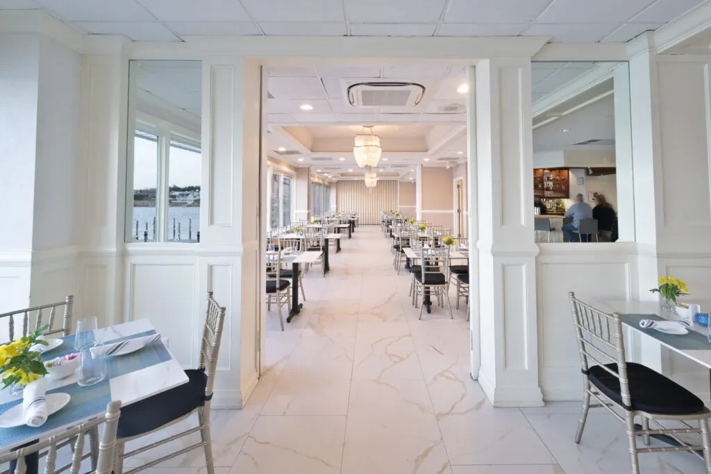 Spacious, elegant restaurant interior with waterfront view and bar.