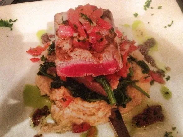 Close-up: Seared tuna with tomato salsa, purée, and greens on a plate.