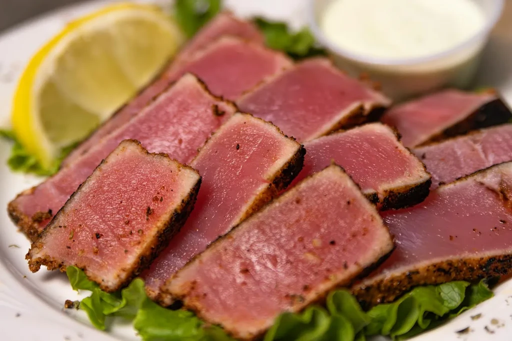 Seared tuna on lettuce with lemon and a creamy sauce.