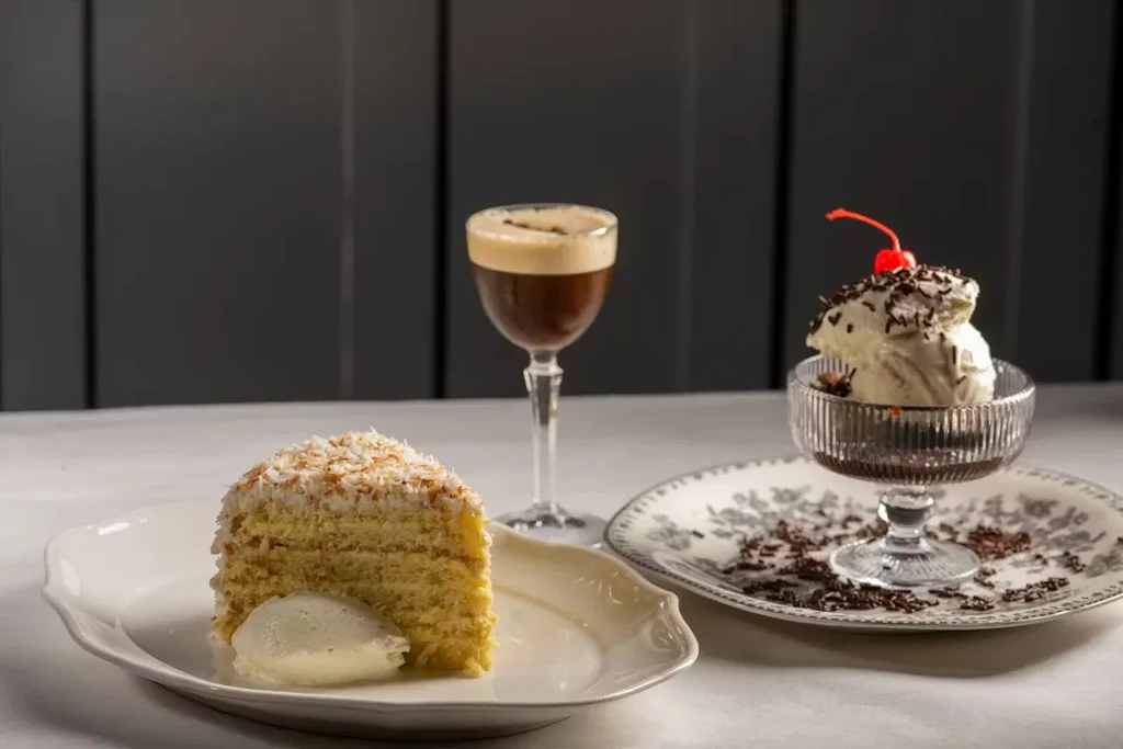 Coconut cake, espresso martini, and ice cream on a table.