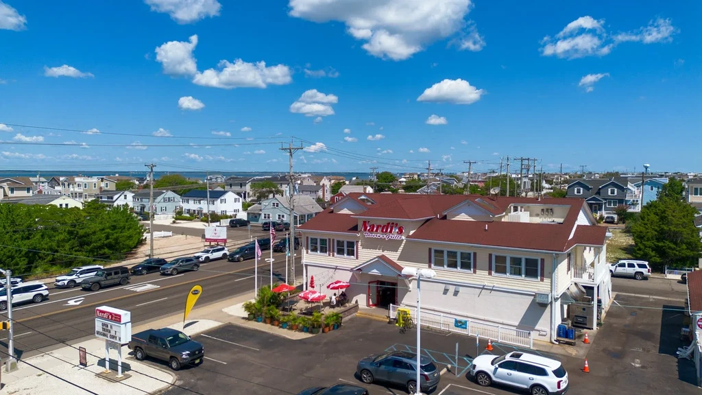Elevated view of Nardi's Tavern & Grille, patio, parking, and coastal town.
