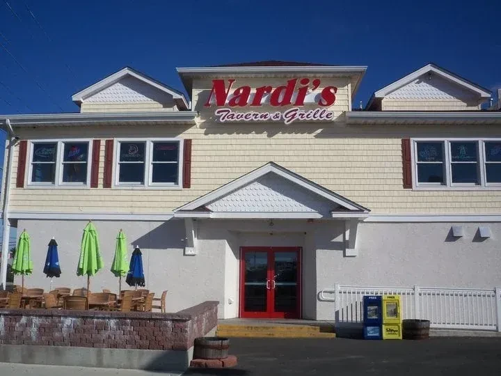 Nardi's Tavern & Grille exterior with yellow siding, red accents, and patio.