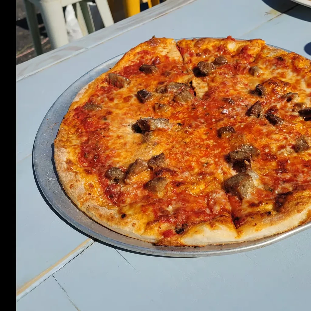 Freshly baked, sliced pizza with melted cheese and savory meat.