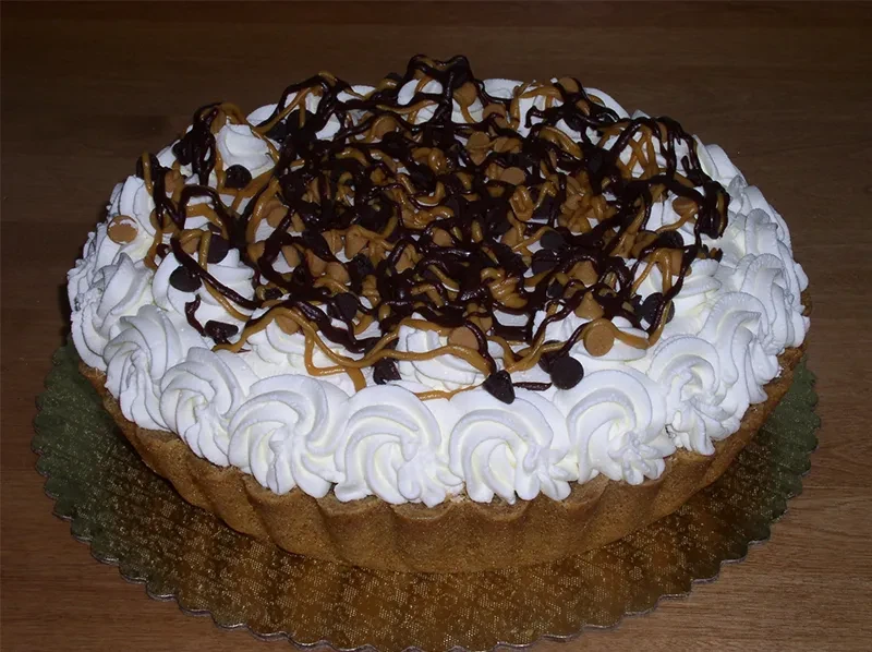 Golden-crusted pie with whipped cream, chocolate, and peanut butter swirls.