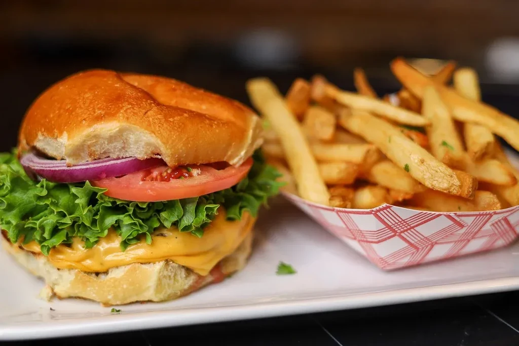 Close-up cheeseburger with fresh toppings and golden french fries.